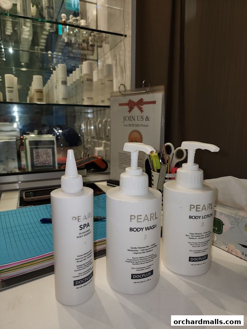 Three white pump bottles of skincare products from the 'Pearl' line by DOCPLUS.