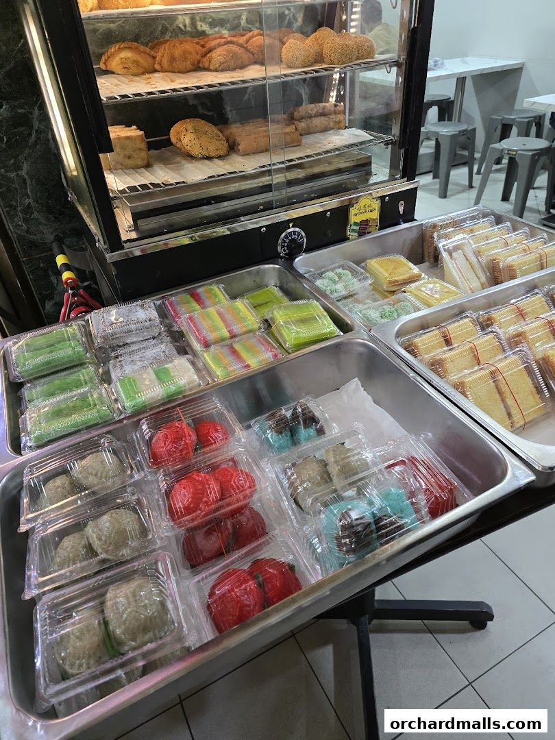 A display of various pastries, cakes, and traditional sweets in clear plastic containers.