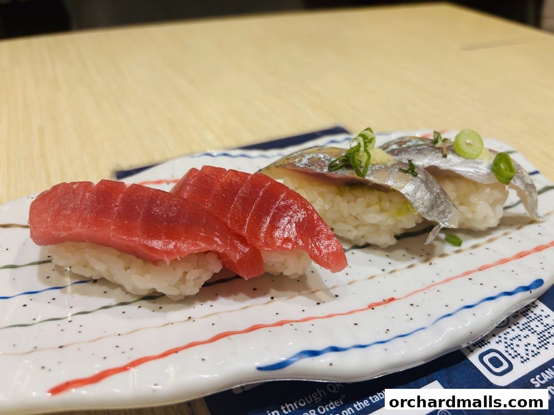 Close-up of fresh tuna and sardine sushi on a decorative plate.