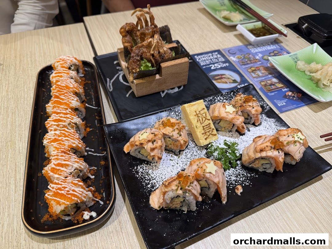 A table laden with various sushi dishes, including rolls and fried items, at Itacho Sushi.