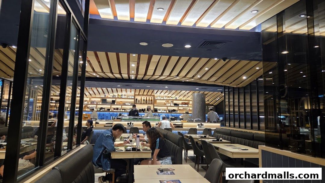 Interior view of Itacho Sushi restaurant with diners and chefs at the sushi bar.