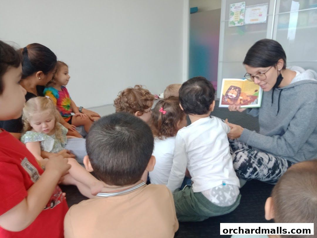 A teacher reads a book to a group of young children sitting on the floor.