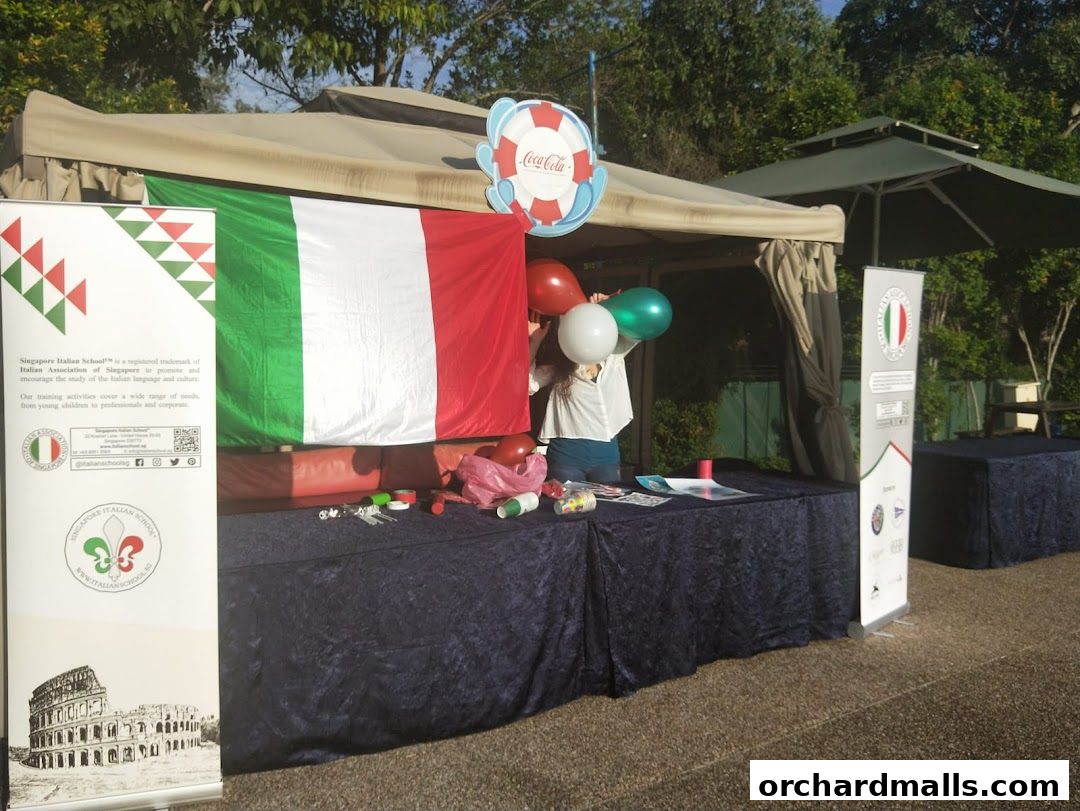 A stall promoting the Singapore Italian School with Italian flags and balloons.