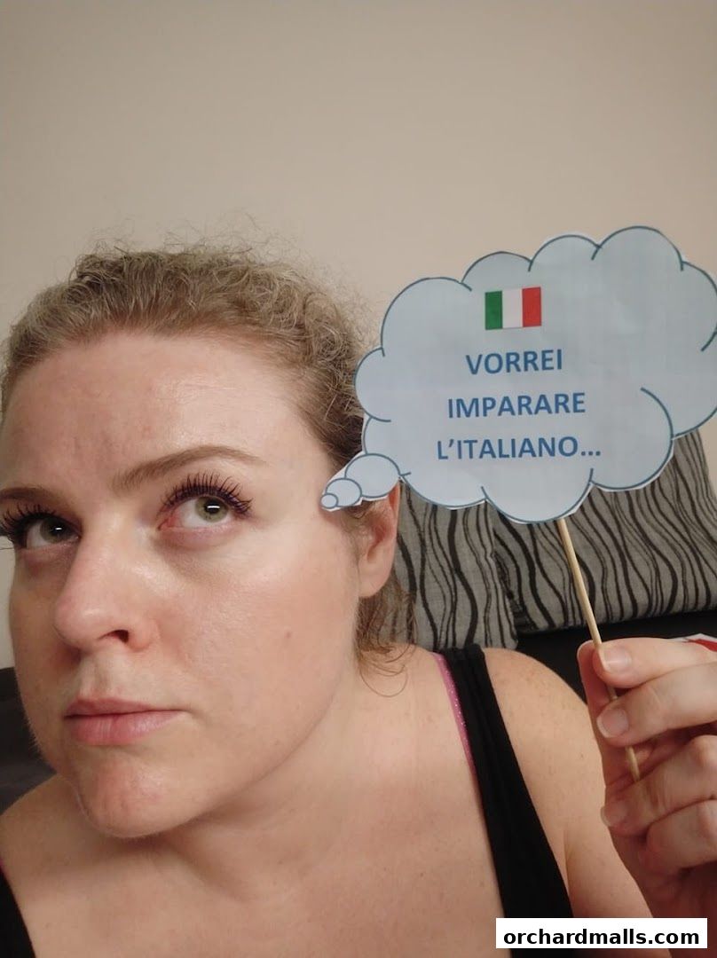 A woman holds a cloud-shaped sign with the Italian flag and text about learning Italian.