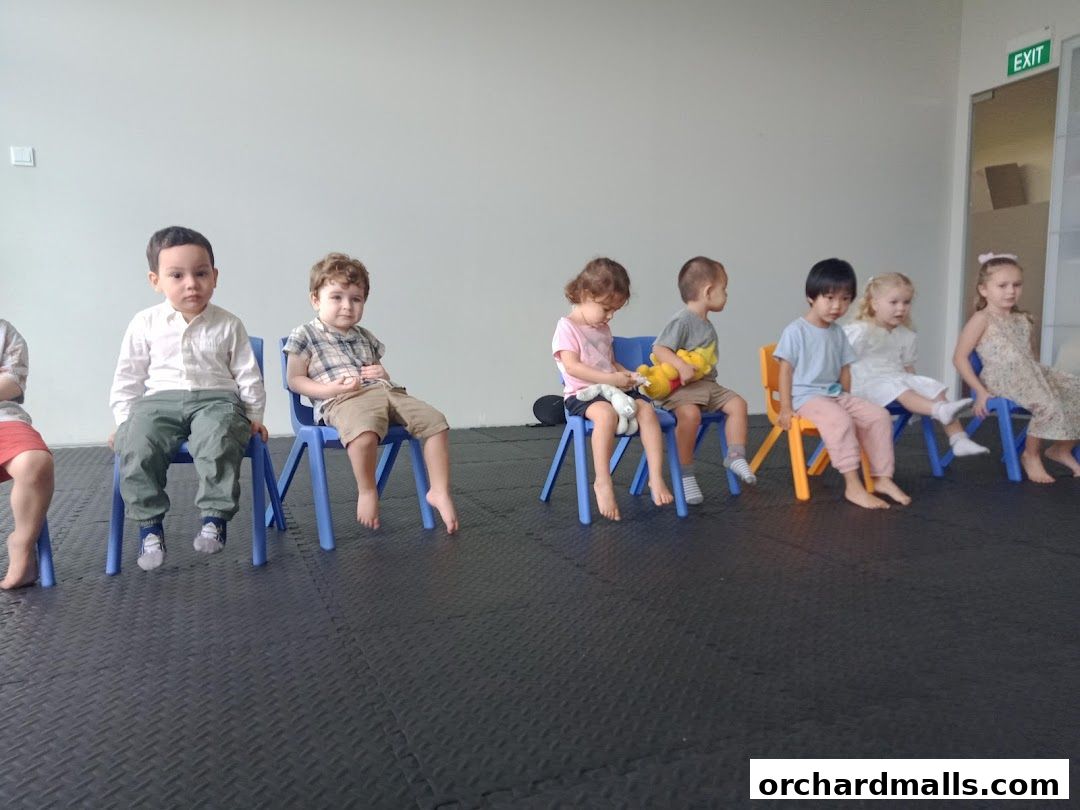 Children sitting on chairs in a classroom setting, possibly for a lesson.