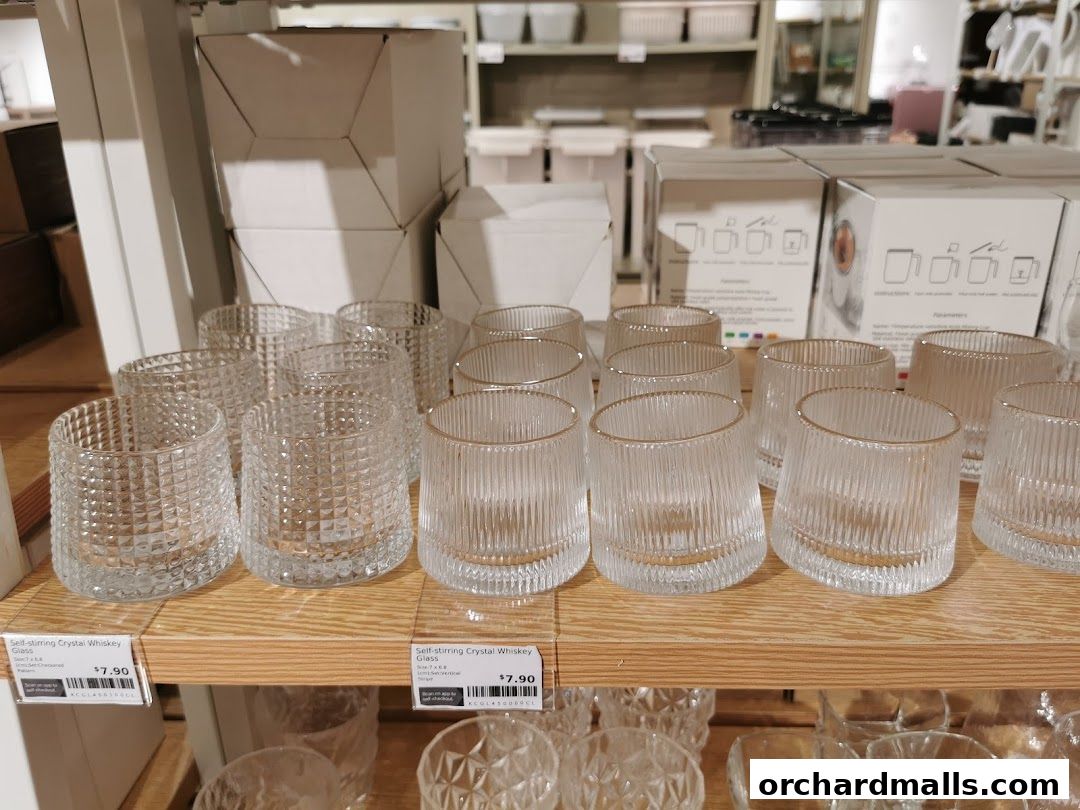Glassware displayed on shelves, featuring various textured and ribbed designs.