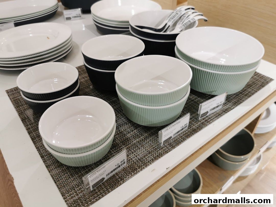 A display of various sizes and colors of ribbed ceramic bowls and plates.