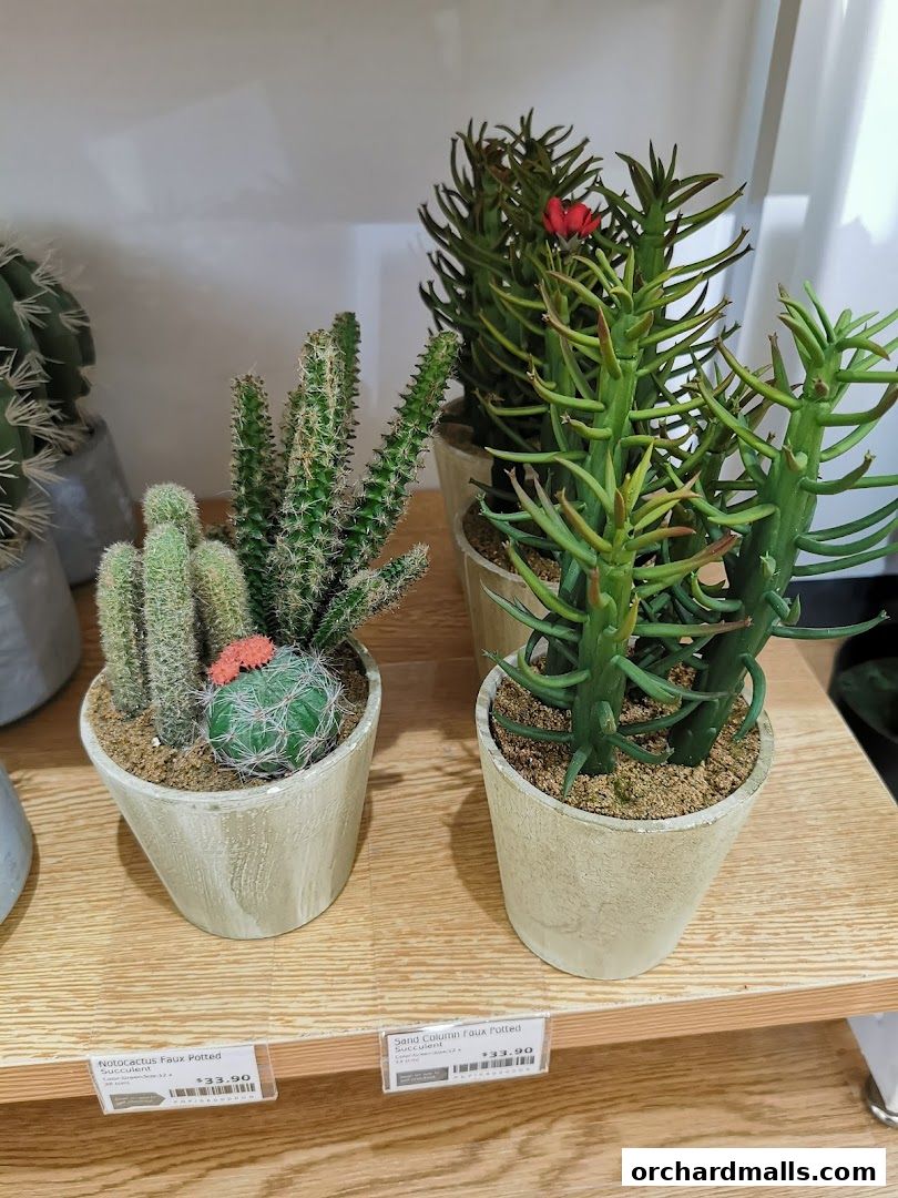 Potted faux cacti and succulents displayed on a wooden shelf.