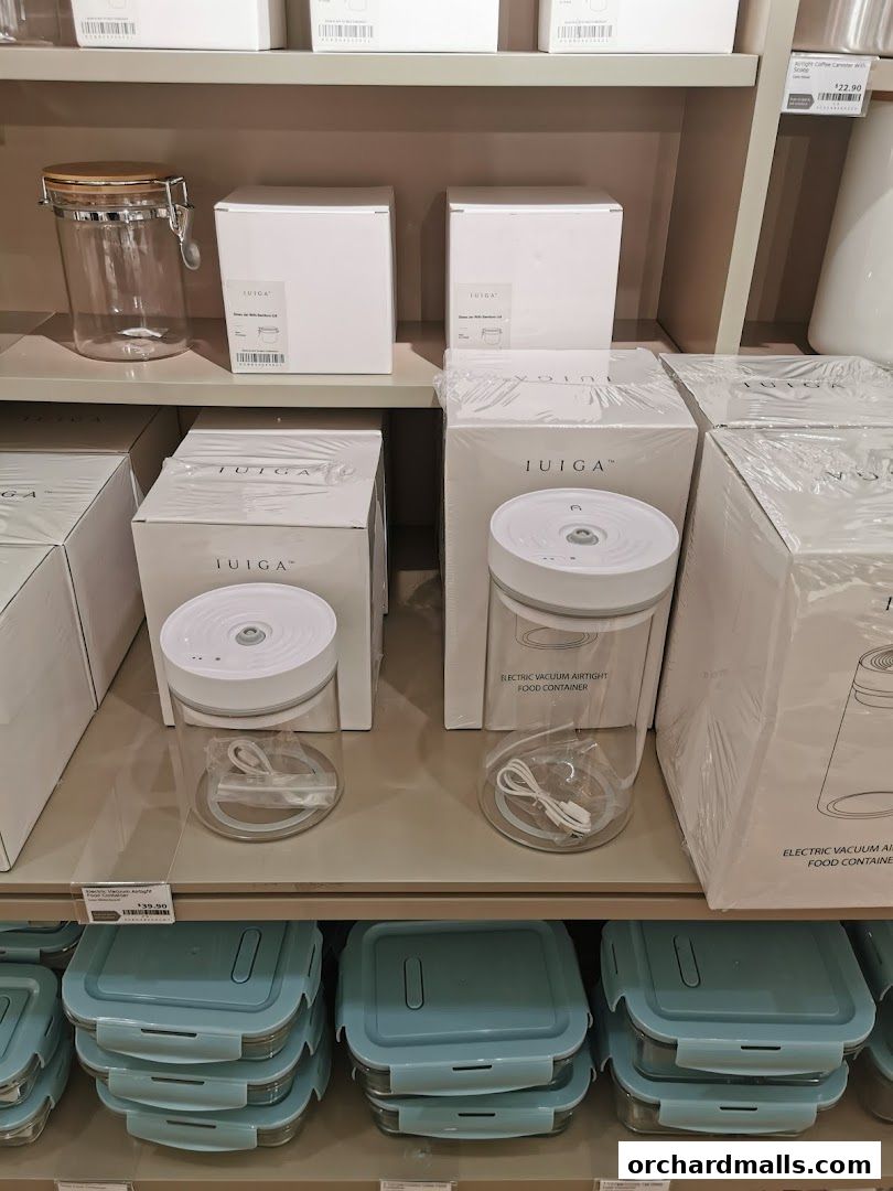Shelves display various IUIGA kitchen storage containers, including glass jars and vacuum-sealed food containers.