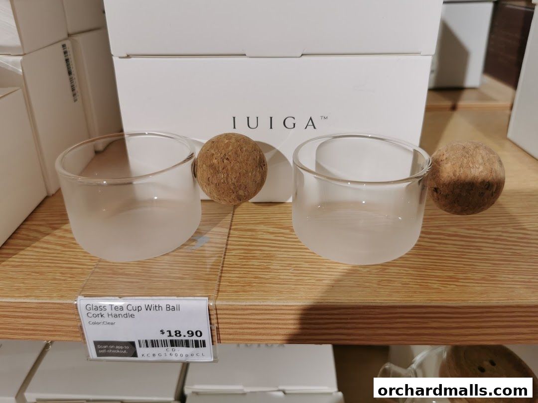 Two frosted glass tea cups with cork handles displayed on a shelf.