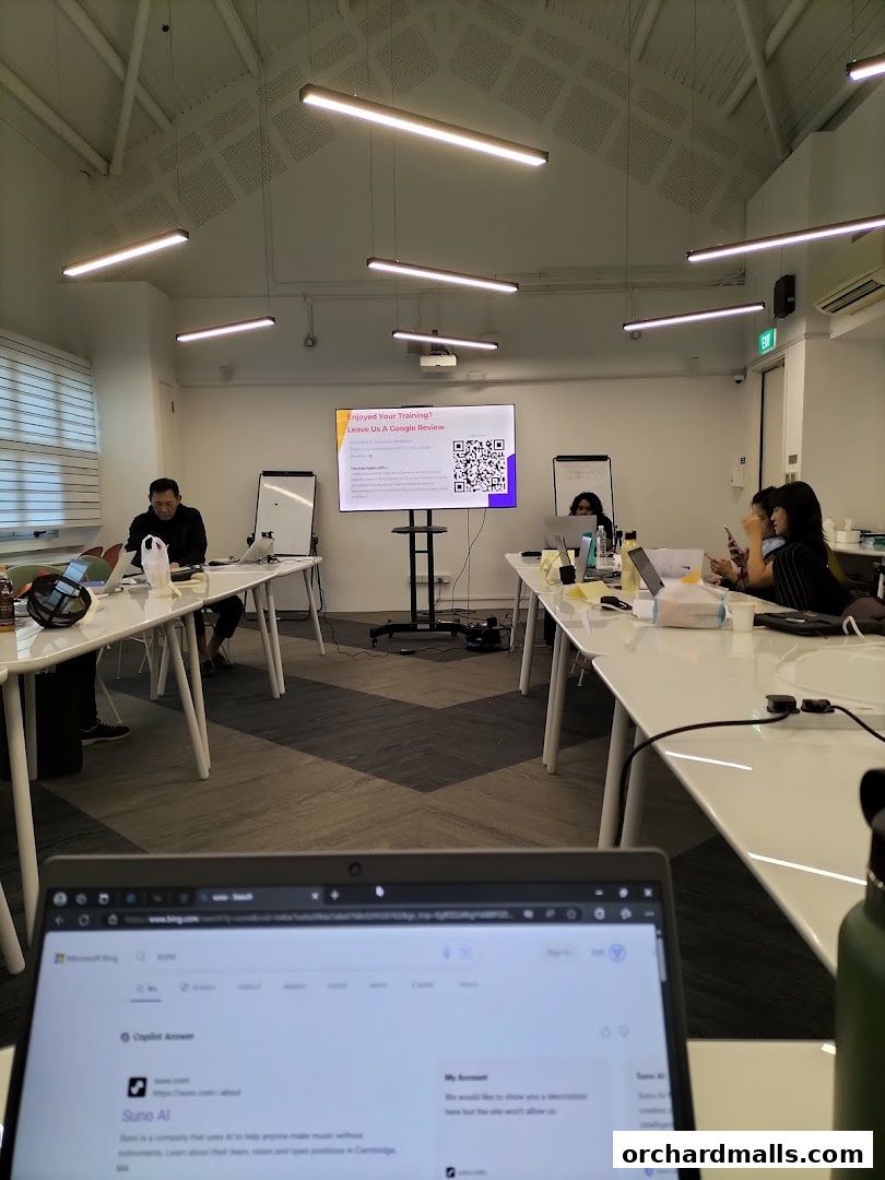 People attending a training session in a modern classroom with a large screen.