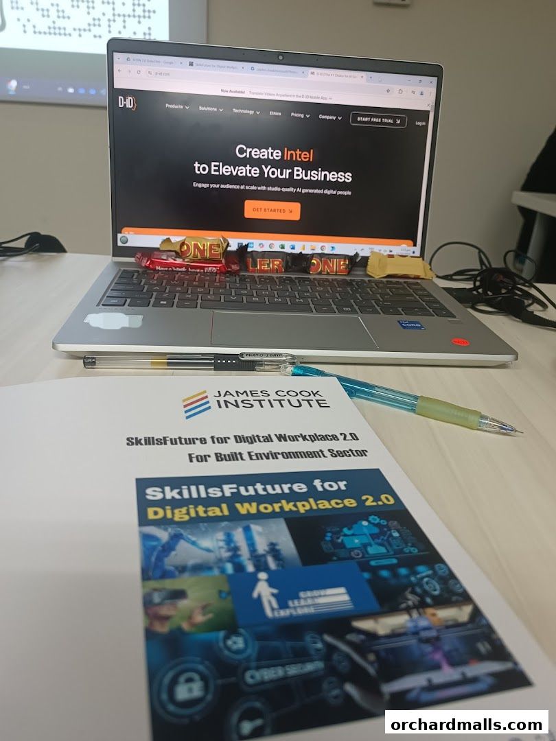 A laptop displays a website for creating AI-generated digital people, with a brochure from James Cook Institute in the foreground.