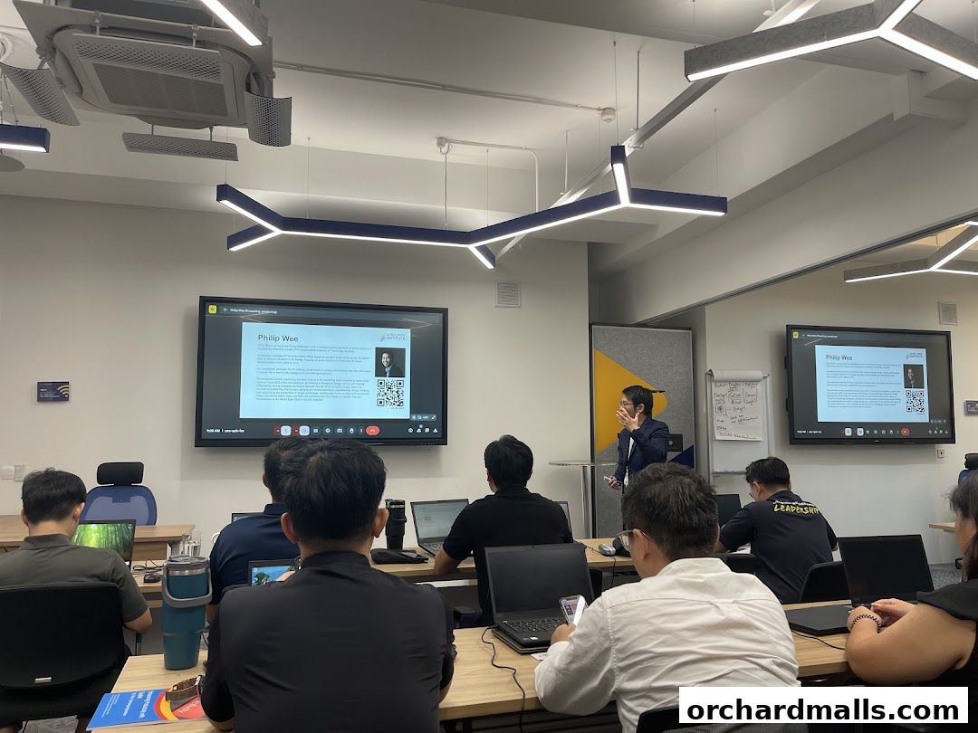 A presenter is giving a lecture to an audience in a modern classroom setting.