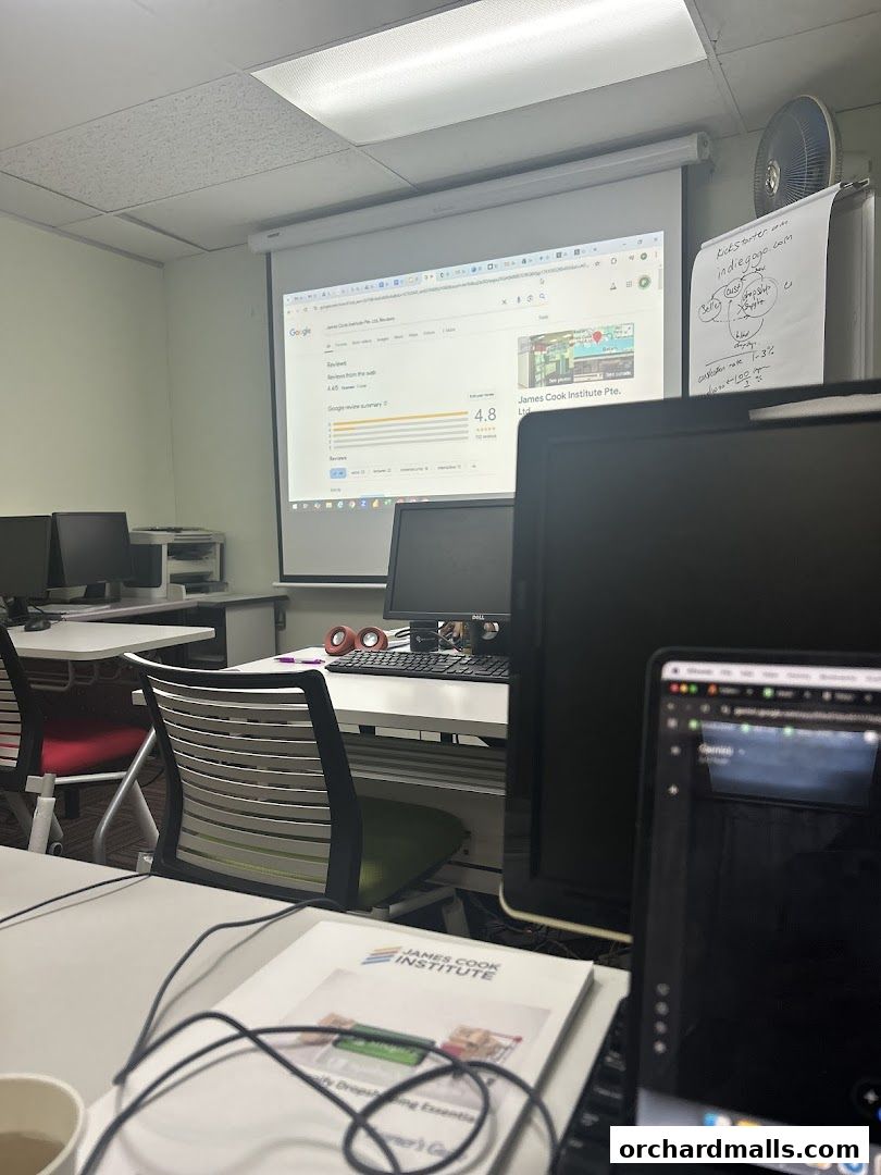 Classroom setting with a projector displaying Google reviews for James Cook Institute.