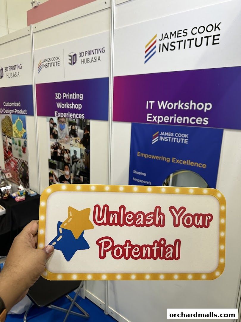 A sign with 'Unleash Your Potential' held in front of booths for James Cook Institute.