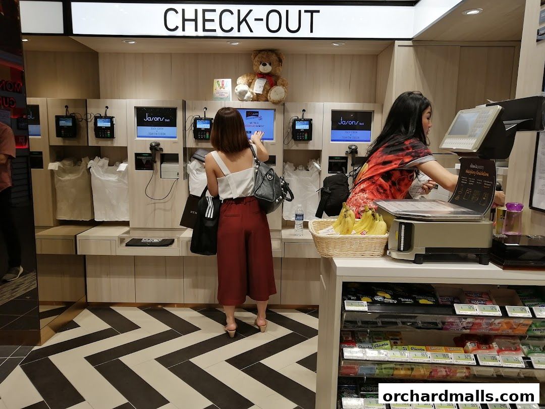 Customers at the self-checkout counters and a staff member at the weighing station in Jason's Deli.