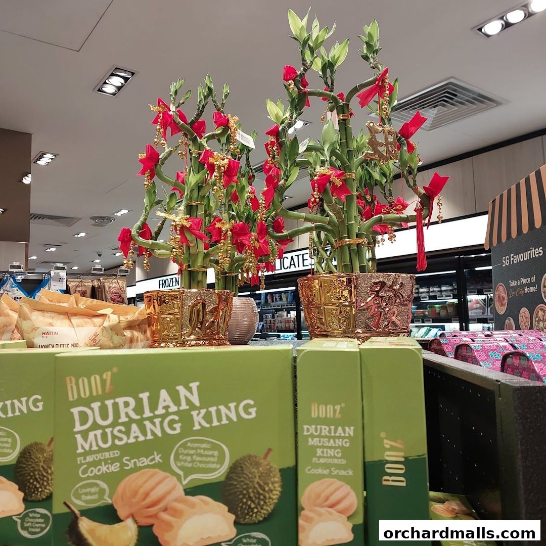 Decorated bamboo plants and boxes of durian flavored cookie snacks are displayed.