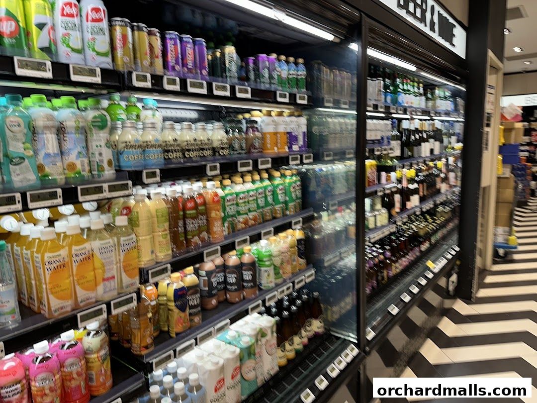 Refrigerated shelves stocked with a wide variety of beverages, including juices, teas, and alcoholic drinks.