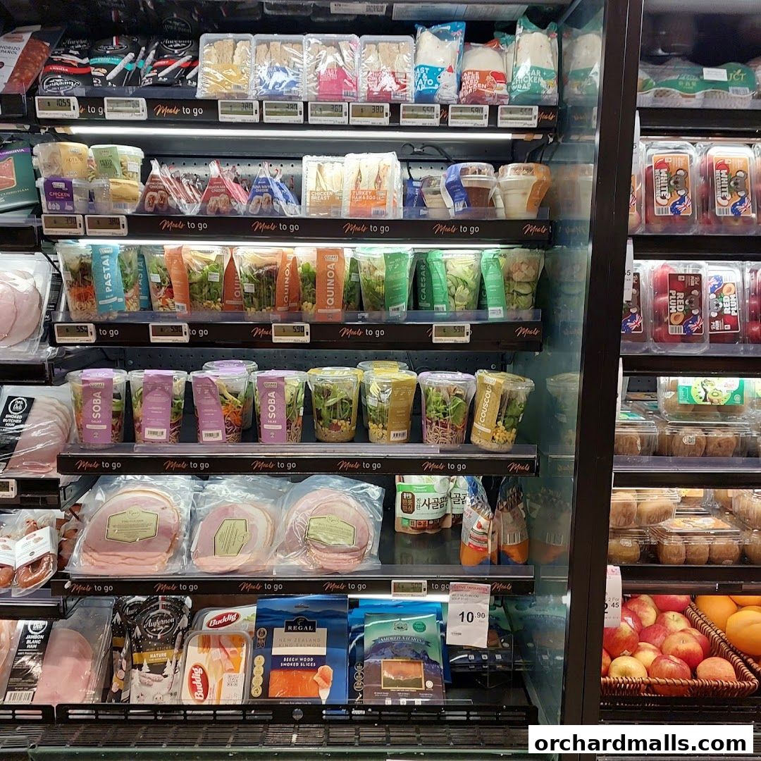 A refrigerated display case filled with pre-packaged meals, salads, sandwiches, and meats.
