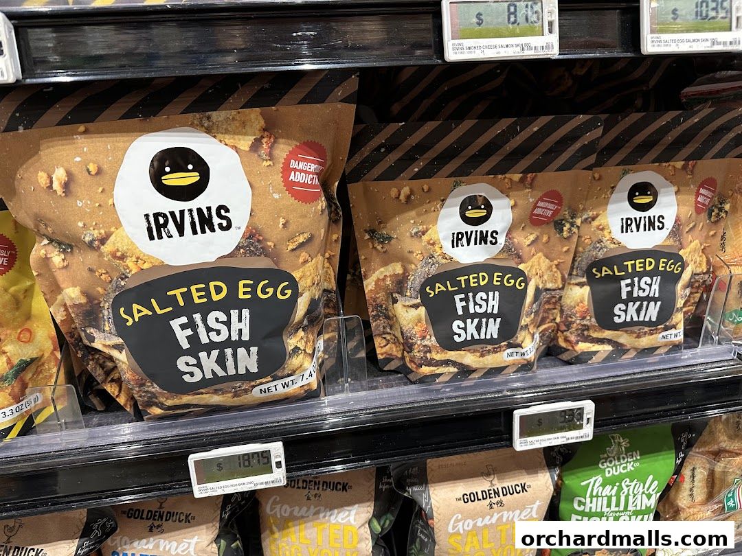 Bags of Irvins Salted Egg Fish Skin snacks displayed on a store shelf.