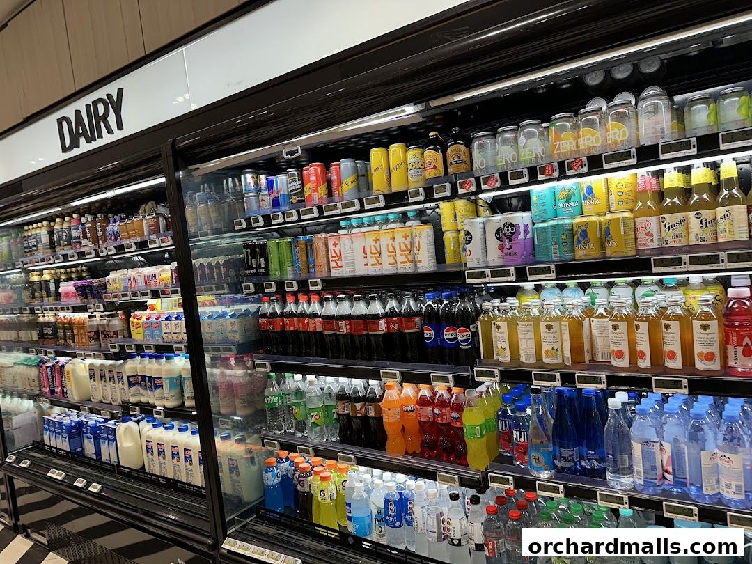 A refrigerated display case filled with various beverages, including dairy, juices, and sodas.