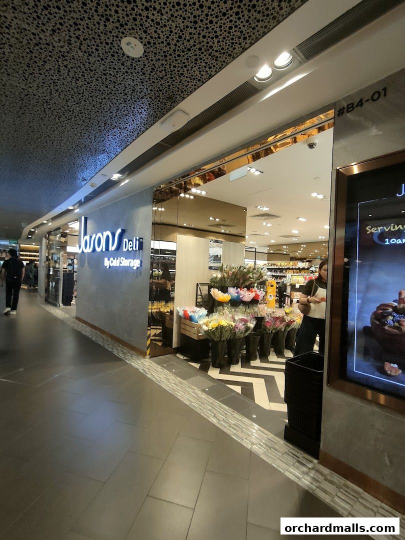 The exterior of Jason's Deli at ION Orchard, featuring a prominent sign and a display of fresh flowers.