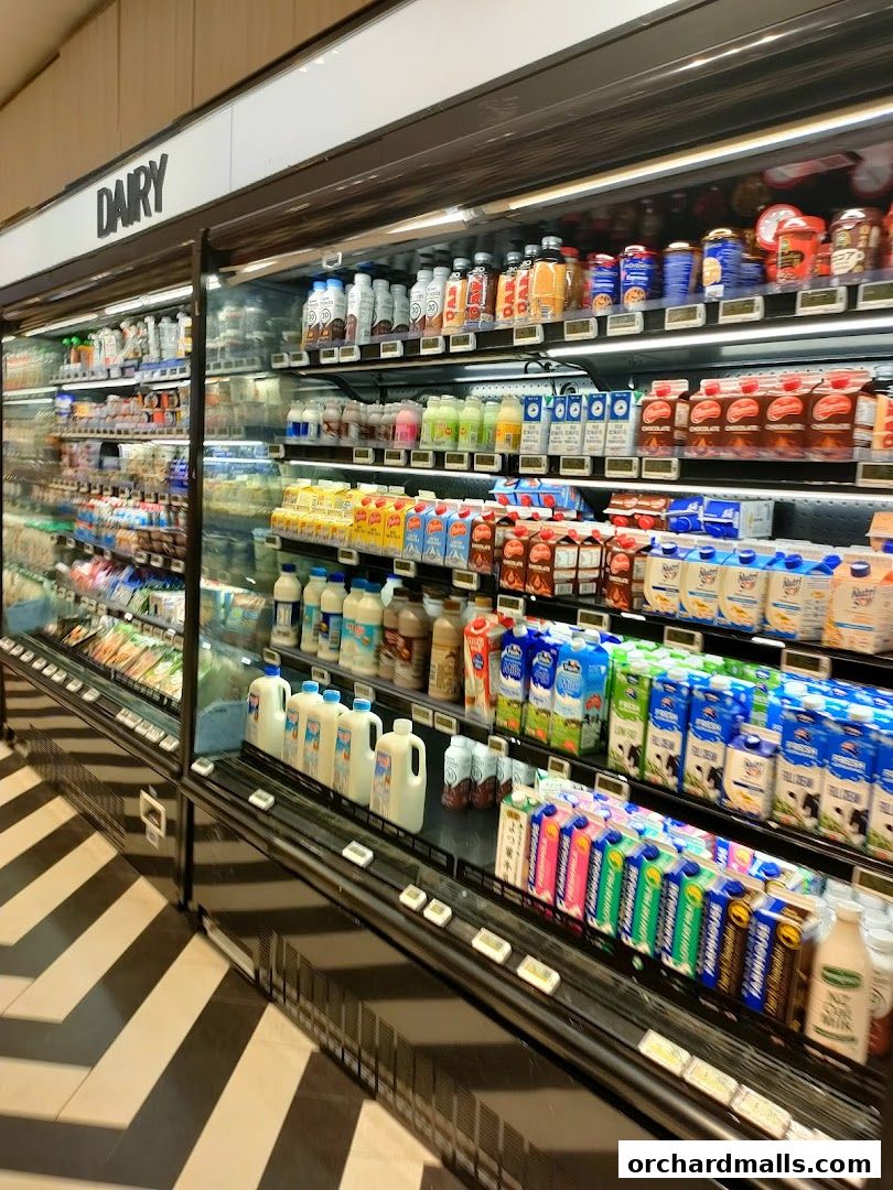 A well-stocked dairy section with various milk cartons and bottles on shelves.