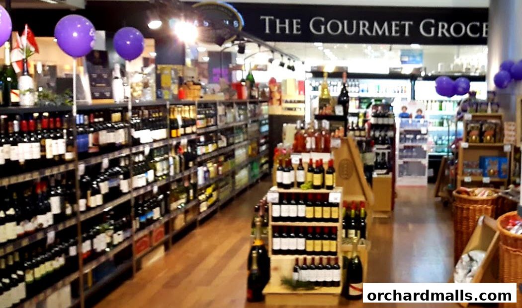 Interior view of a gourmet grocery store with shelves stocked with wine bottles and other products.