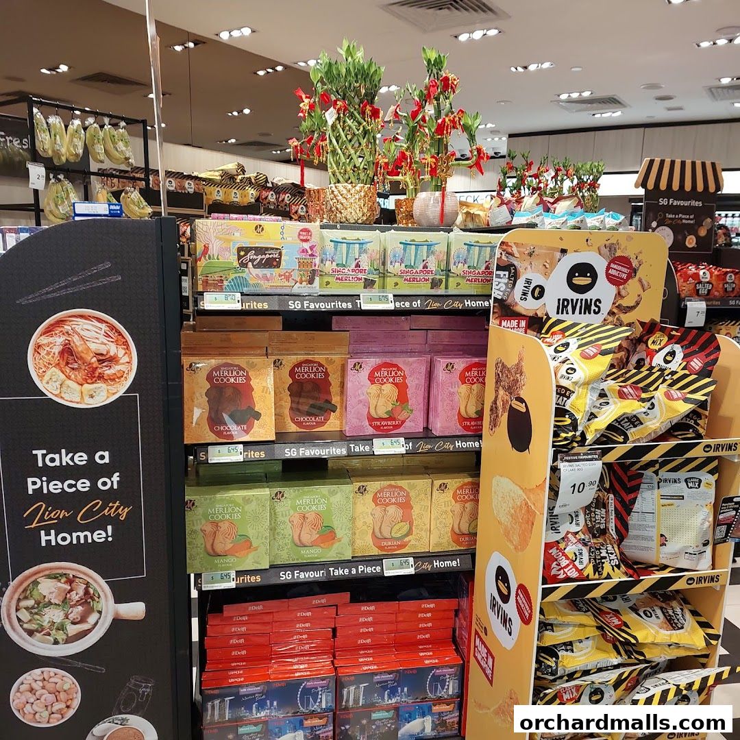 A display of Singaporean snacks and cookies, including Merlion Cookies and Irvins Salted Egg Potato Chips.