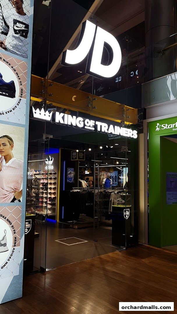 The entrance to JD King Of Trainers, a shoe store with a large illuminated JD logo.