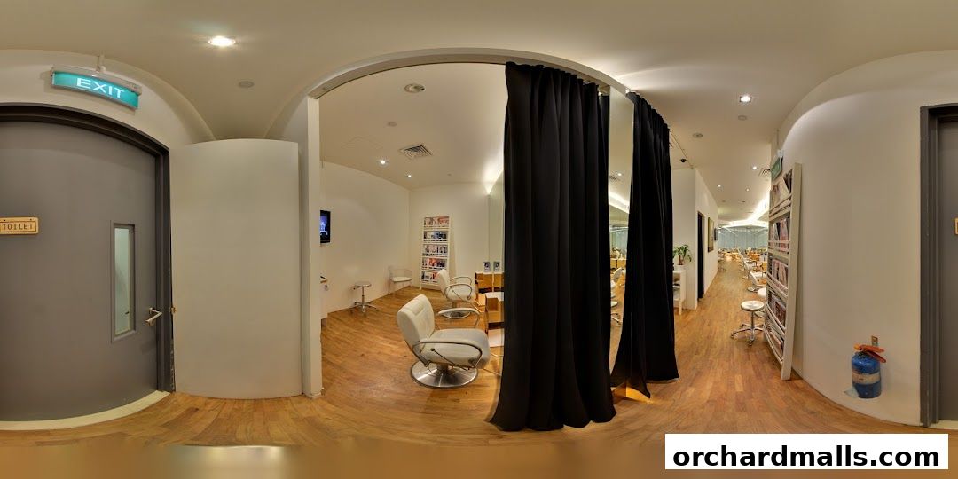 Interior view of a modern salon with styling chairs, a magazine rack, and an exit sign.