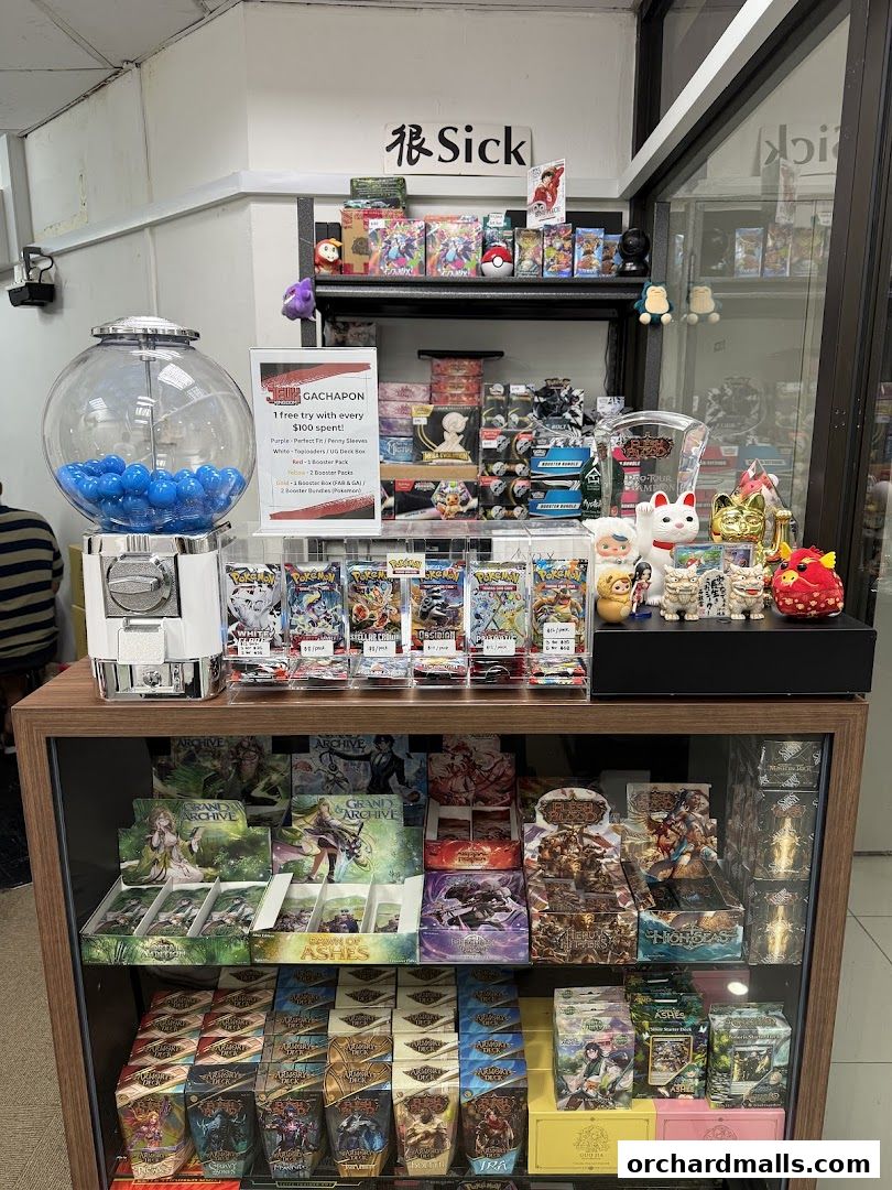 A display of trading cards, booster packs, and gachapon balls in a retail shop.
