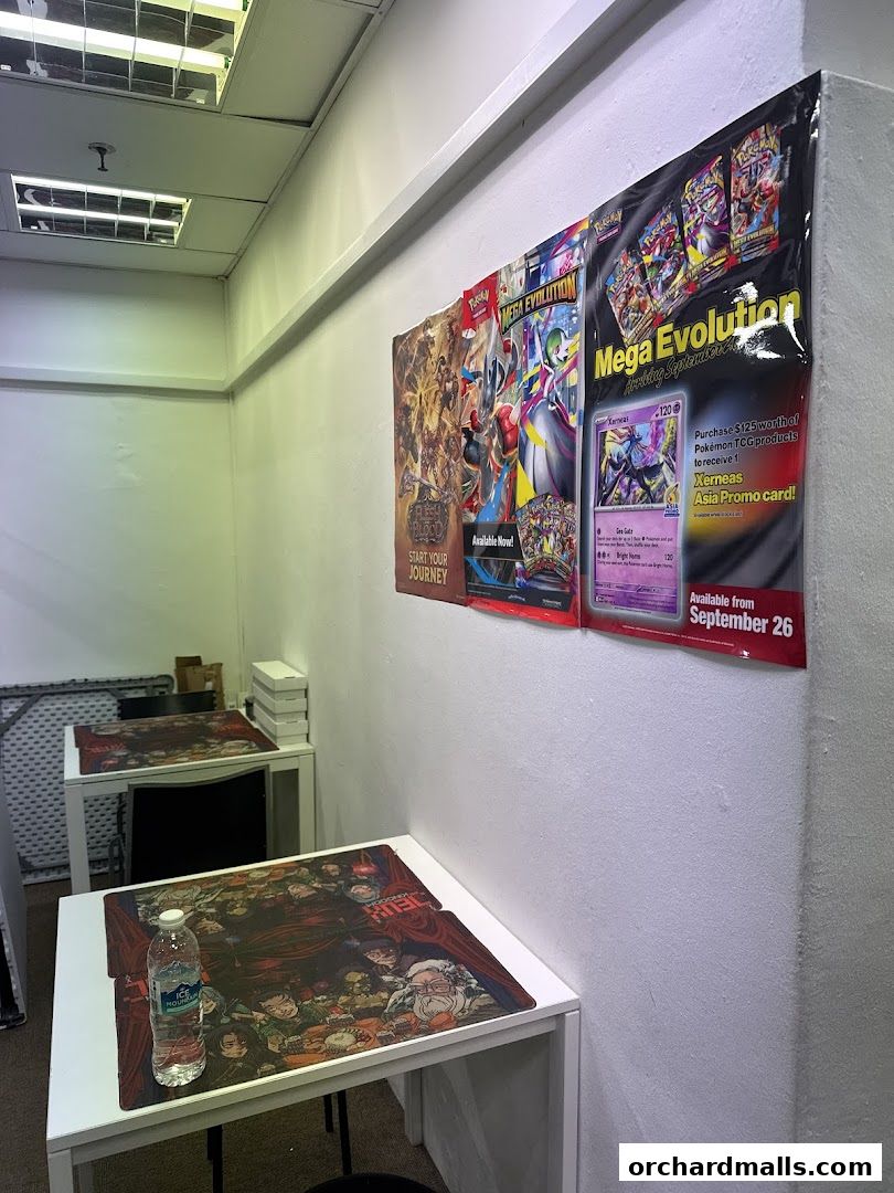 Interior of a shop with tables set up for card games and posters on the wall.