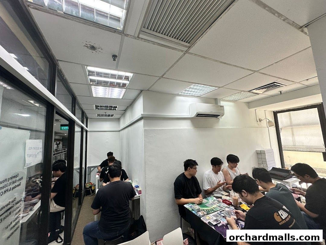 People gathered around tables playing card games in a retail space.