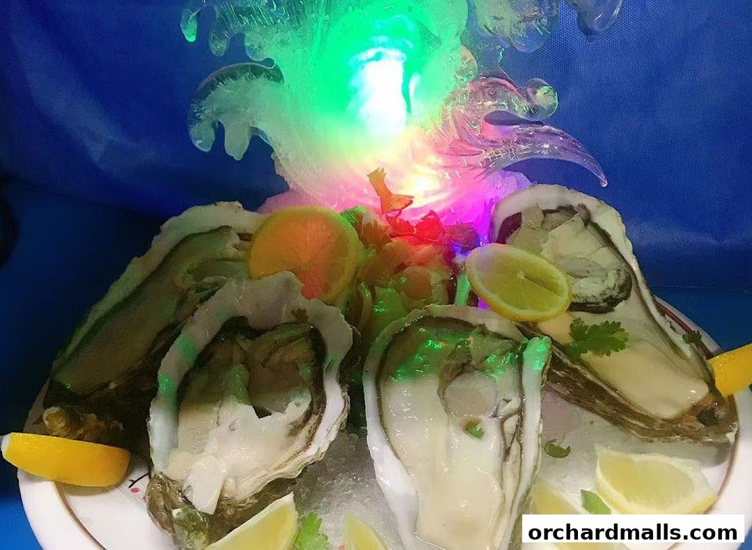 Fresh oysters served on ice with lemon slices and a colorful ice sculpture.