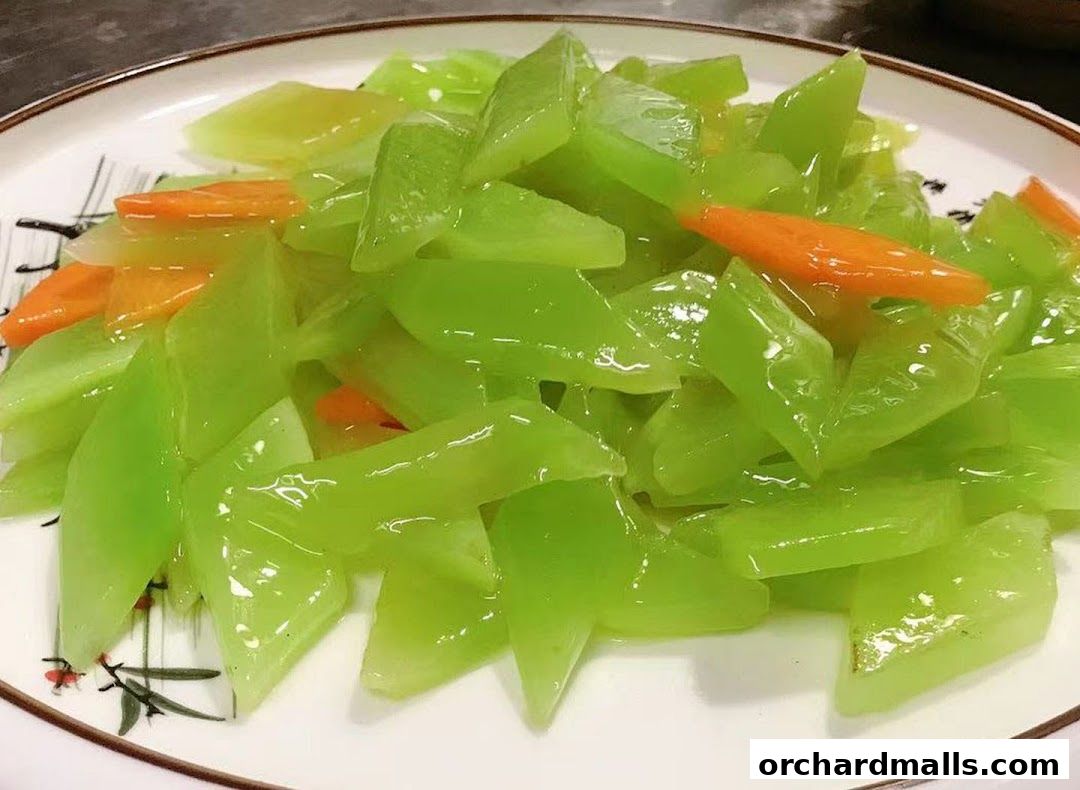 A plate of stir-fried green vegetables with carrots, glistening with sauce.