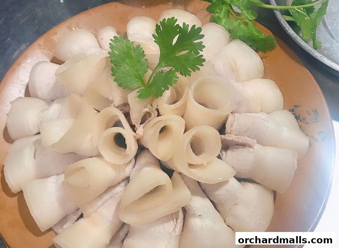 A plate of thinly sliced, rolled pork belly with cilantro garnish.