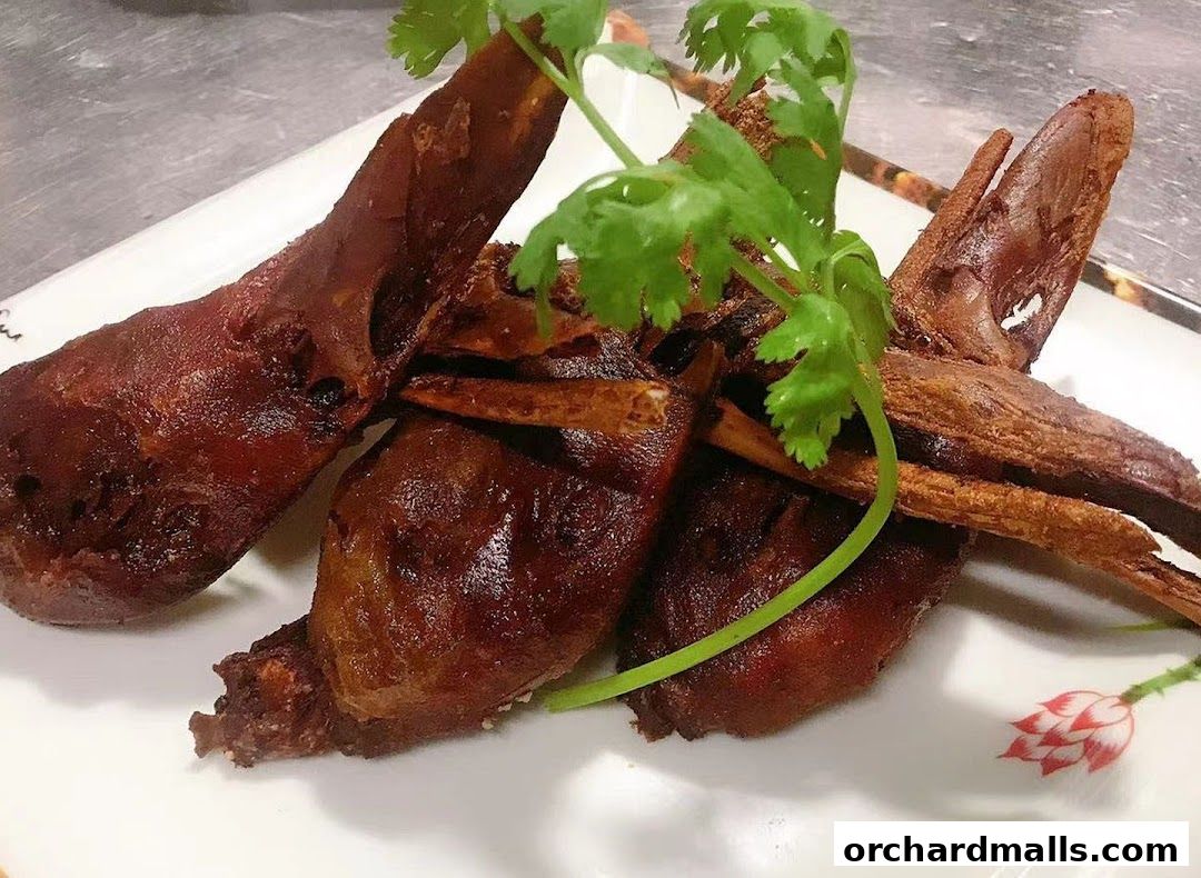 A plate of crispy, deep-fried duck tongues garnished with fresh cilantro.