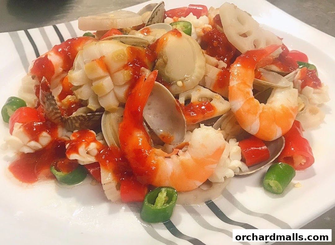 A plate of seafood with shrimp, clams, and lotus root in a spicy sauce.