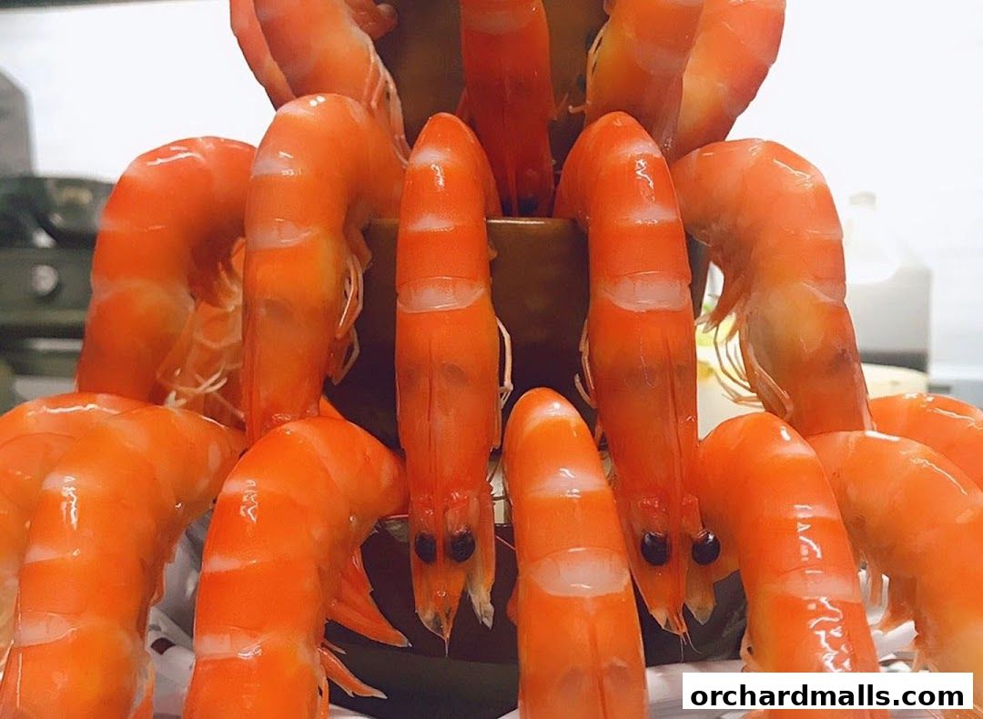 A close-up shot of a platter filled with freshly cooked, vibrant orange shrimp.