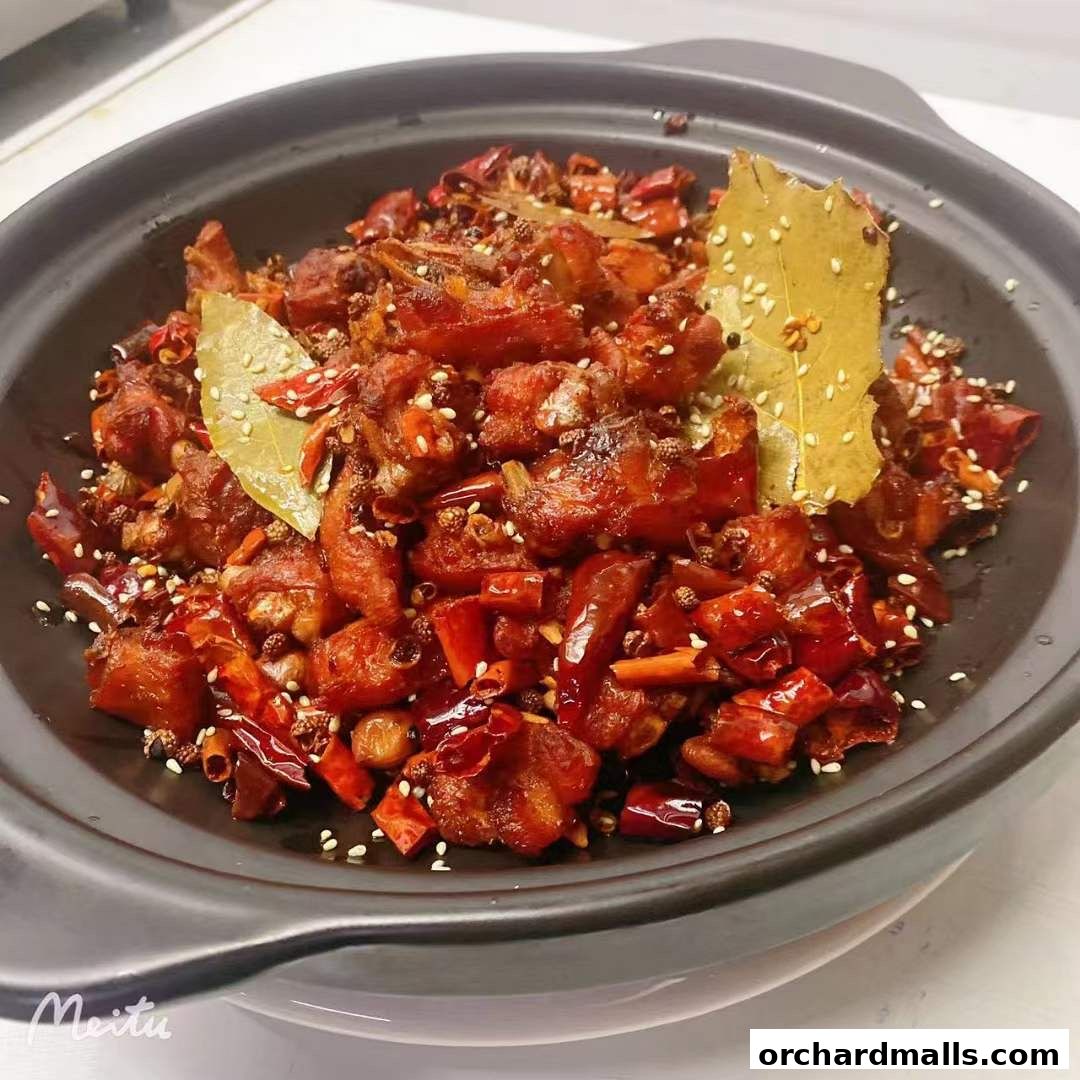 A close-up of a spicy, deep-fried chicken dish with chili peppers and sesame seeds.