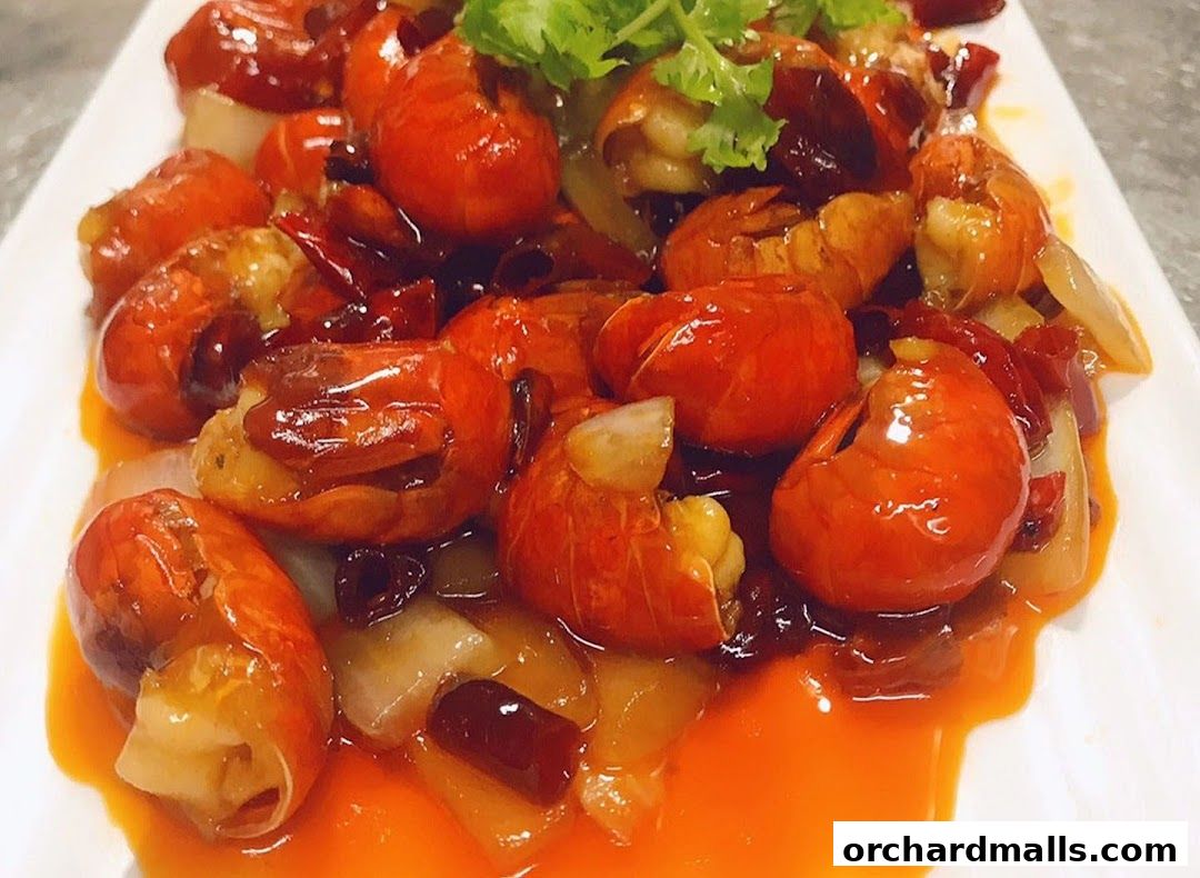A plate of spicy crawfish with chili peppers and herbs, garnished with cilantro.