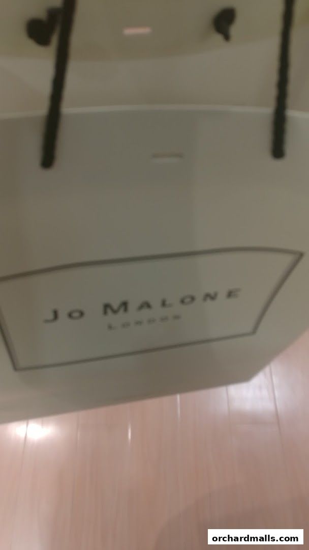 A white shopping bag with the Jo Malone London logo and handles.