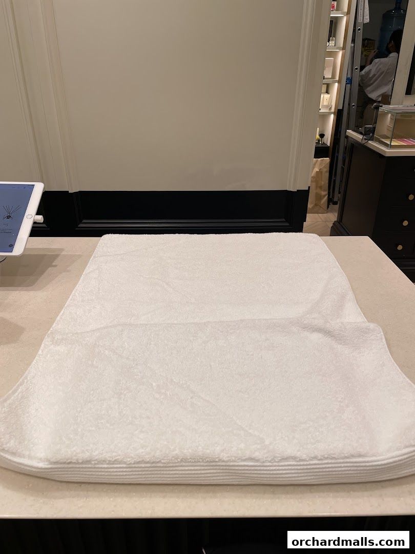 A neatly folded white towel on a counter in a Jo Malone London store.