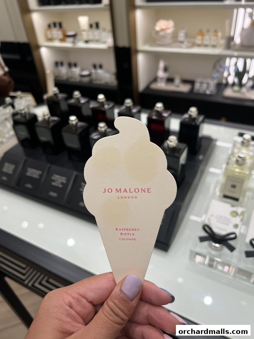 A hand holds a Jo Malone London ice cream cone shaped scent sample.