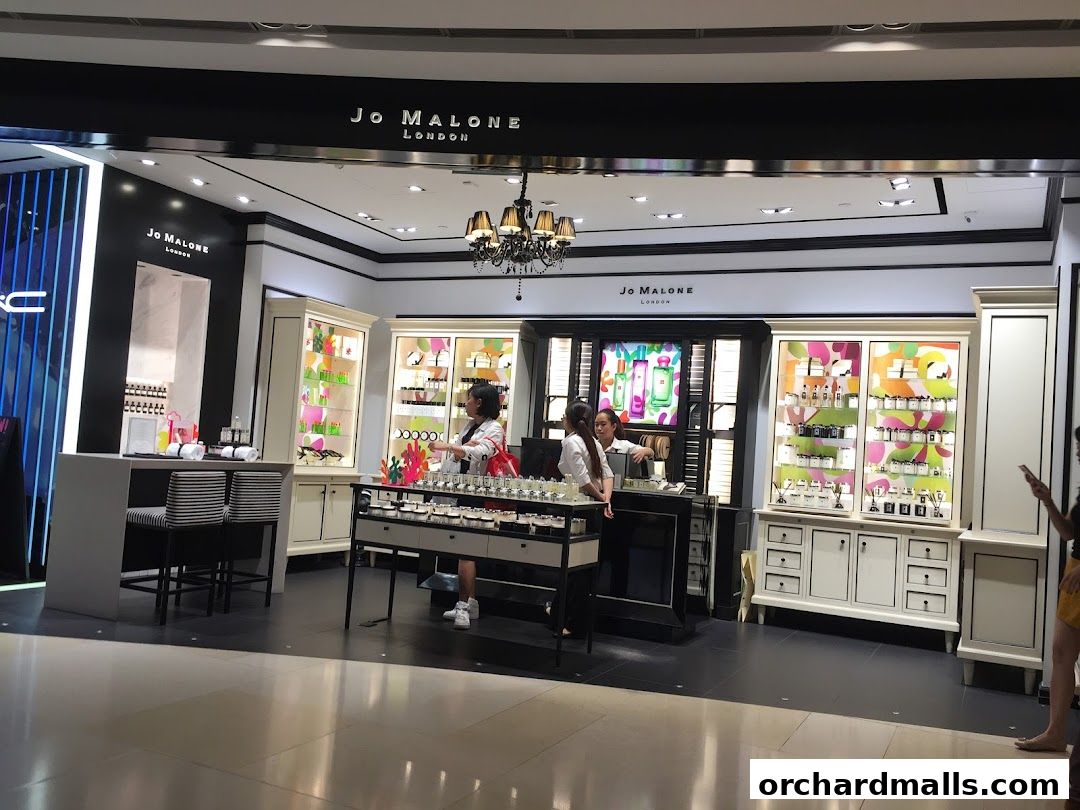 Jo Malone London shop interior with displays of perfumes and staff assisting customers.