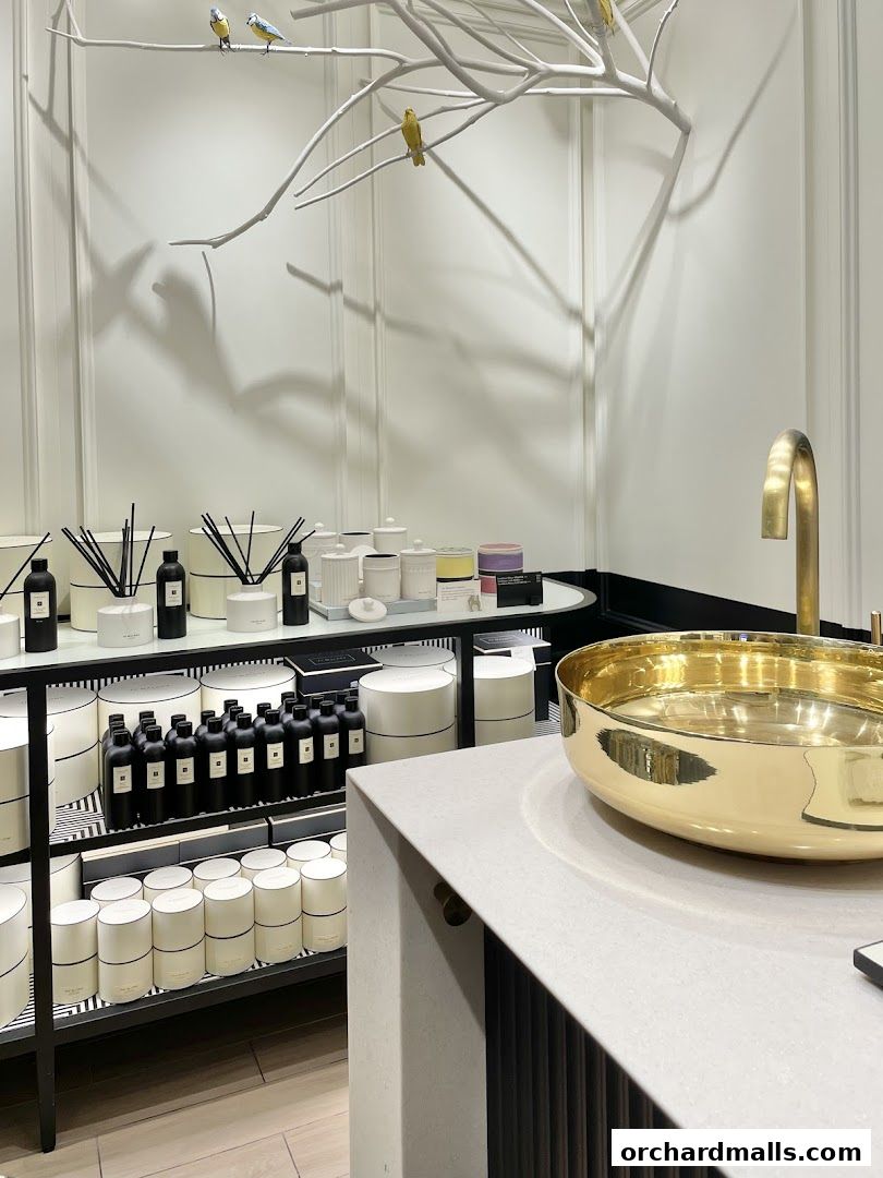 Interior of a Jo Malone London shop with diffusers, candles, and a decorative bird branch.