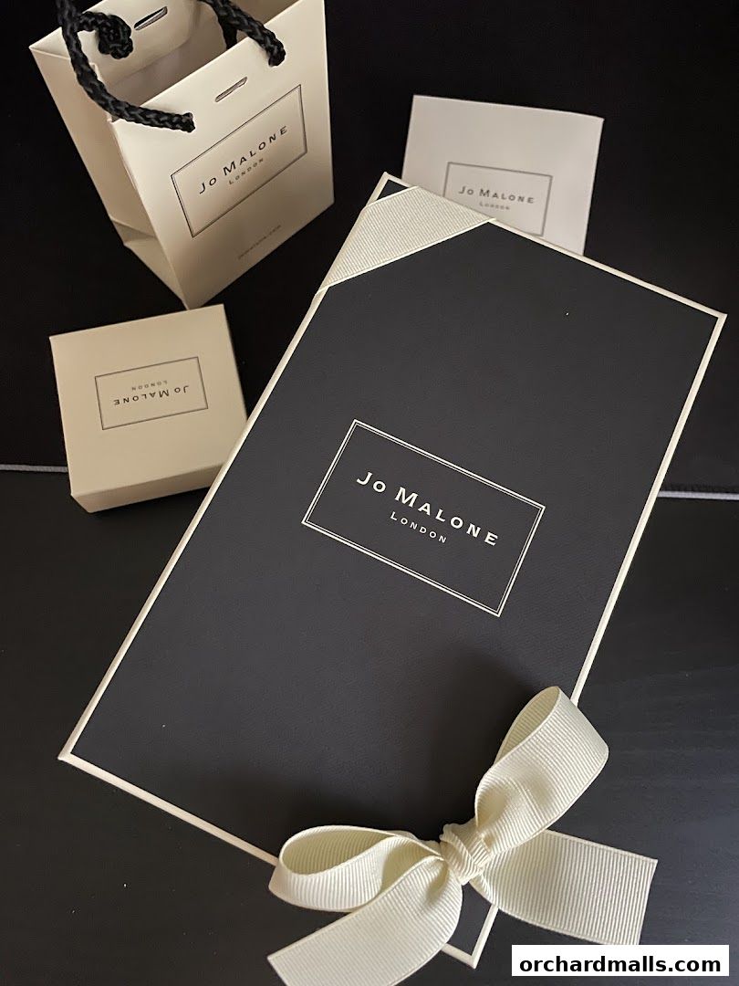 Jo Malone London gift packaging with a ribbon-tied box and shopping bags.