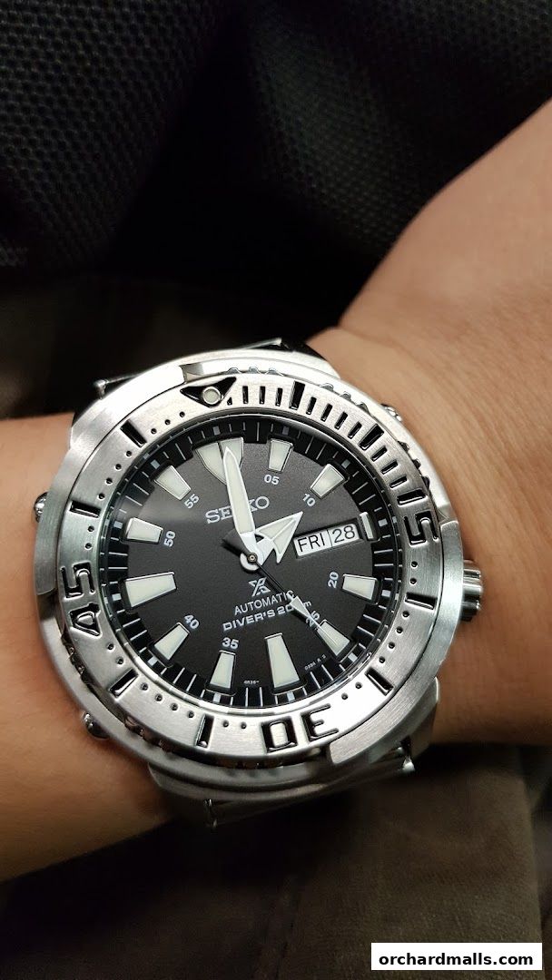 A close-up shot of a person wearing a Seiko automatic diver's watch.