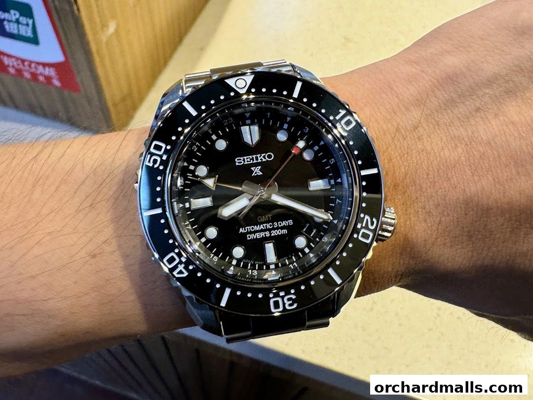 A close-up shot of a Seiko automatic GMT diver's watch on a person's wrist.